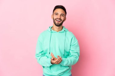 Pembe arka planda izole edilmiş genç beyaz adam gülüyor.