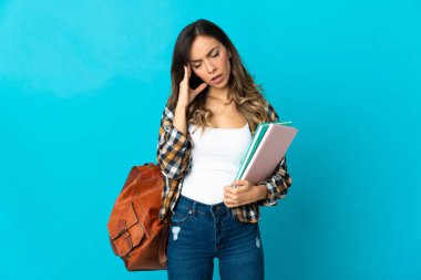 Mavi arka planda başağrısı olan genç bir bayan öğrenci.