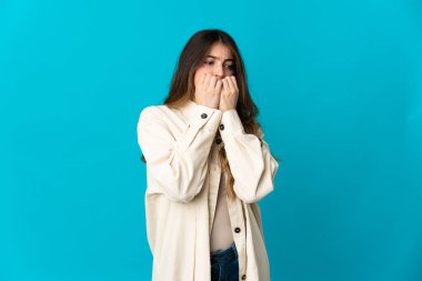 Mavi arka planda izole edilmiş beyaz bir kadın gergin ve korkmuş bir şekilde elleriyle suni teneffüs yapıyor.