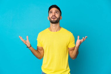 Mavi arka planda izole edilmiş genç beyaz adam bunalıma girdi.