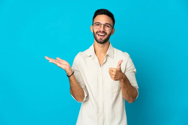 Joven Hombre Caucásico Aislado Sobre Fondo Azul Sosteniendo Espacio Copia — Foto de Stock