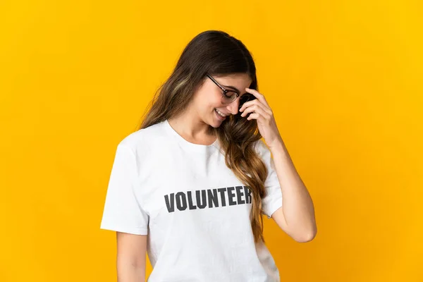 Joven Voluntaria Aislada Sobre Fondo Amarillo Riendo — Foto de Stock