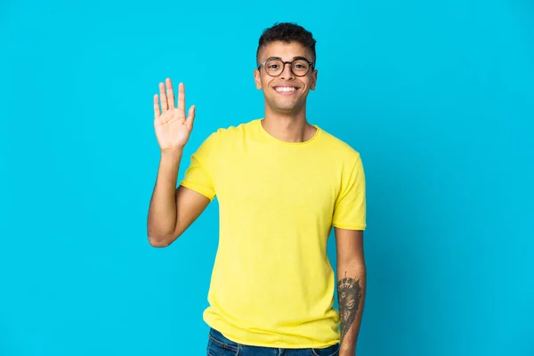 Ung Brasiliansk Man Isolerad Blå Bakgrund Hälsning Med Handen Med — Stockfoto