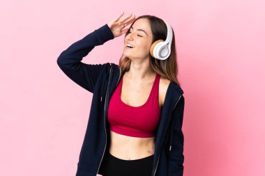 Genç Romen spor kadını pembe arka planda izole edilmiş, gülümsüyor.