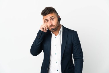 Tele pazarlamacı beyaz arka planda izole edilmiş bir kulaklıkla çalışıyor.