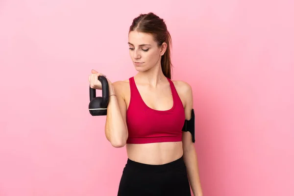 Jonge Sport Vrouw Geïsoleerde Roze Achtergrond Maken Gewichtheffen Met Kettlebell — Stockfoto