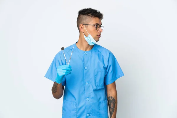 Βραζιλιάνος Οδοντίατρος Κρατώντας Εργαλείο Απομονώνονται Λευκό Φόντο Κοιτάζοντας Προς Πλάγια — Φωτογραφία Αρχείου