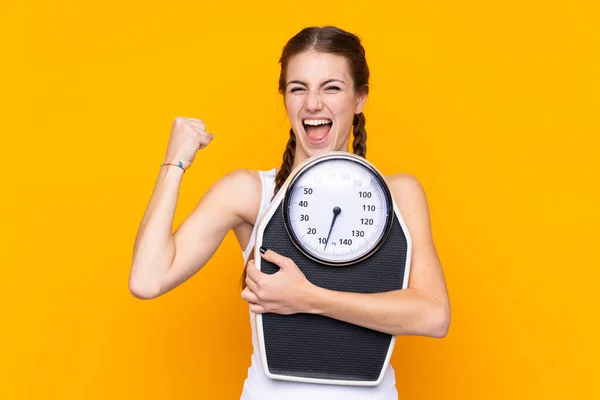 Jonge Vrouw Geïsoleerde Gele Achtergrond Met Weegmachine Het Doen Van — Stockfoto