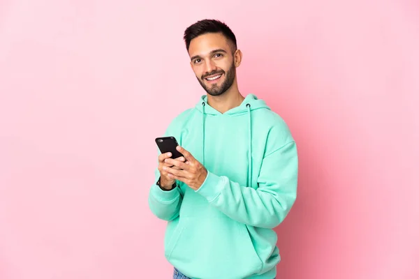 Joven Hombre Caucásico Aislado Sobre Fondo Rosa Enviando Mensaje Con —  Fotos de Stock