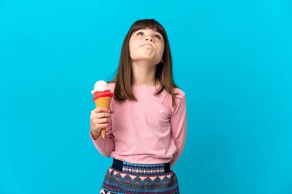 Kleines Mädchen Mit Kornetteis Auf Blauem Hintergrund Und Blick Nach — Stockfoto