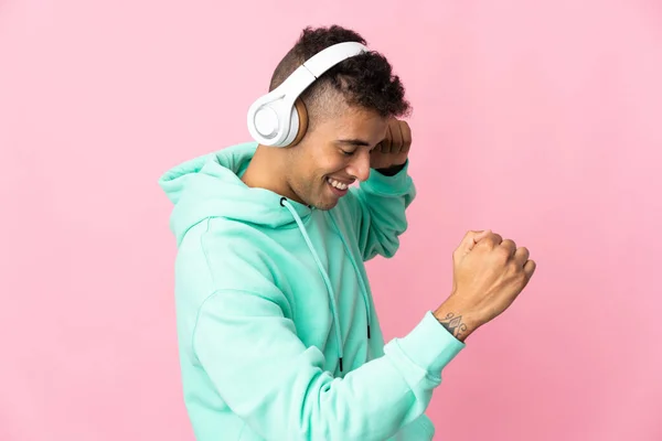 Jonge Braziliaanse Man Geïsoleerd Roze Achtergrond Luisteren Muziek Dansen — Stockfoto