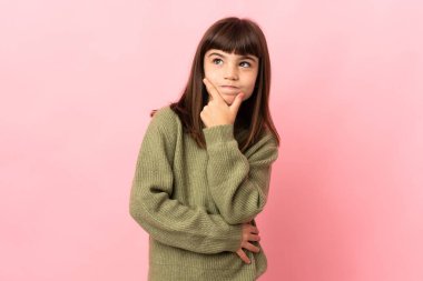 Pembe arka planda izole edilmiş küçük kızın şüpheleri var.