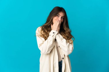 Genç beyaz kadın mavi arka planda izole edilmiş mutlu ve gülümseyen elleri ve ağzı kapalı.