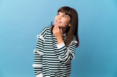 İzole edilmiş küçük kız gülümserken yukarı bakıyor.