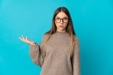 Genç Litvanyalı kadın mavi arka planda izole edilmiş.