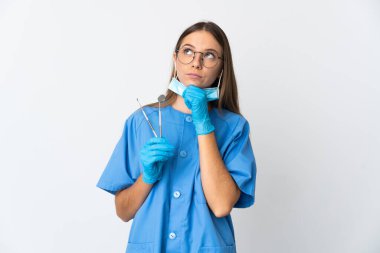 Litvanyalı kadın diş hekimi, izole edilmiş arka plan üzerinde aletler tutuyor ve