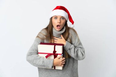 Elinde Noel şapkası olan Litvanyalı bir kadın beyaz arka planda izole edilmiş, şaşırmış ve şaşırmış bir şekilde duruyor.