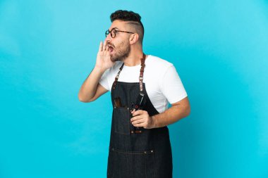 Önlüklü bir berber ağzı açık bağırıyor.