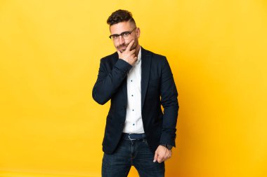 İzole edilmiş sarı arka plan düşüncesi üzerinde iş adamı