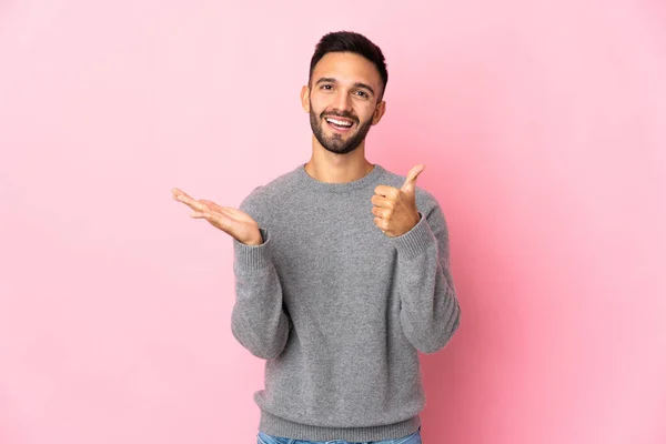 Jonge Blanke Man Geïsoleerd Roze Achtergrond Houden Copyspace Imaginaire Palm — Stockfoto