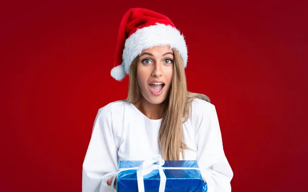 Vacanze Natale Giovane Donna Bionda Possesso Regalo Sfondo Rosso Isolato — Foto Stock