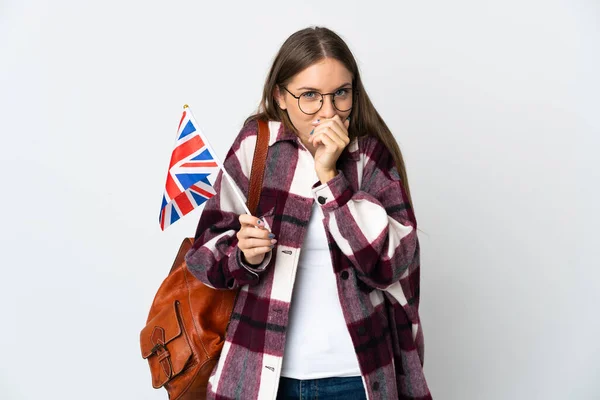 Young Lithuanian woman holding an United Kingdom flag isolated on white background happy and smiling covering mouth with hands