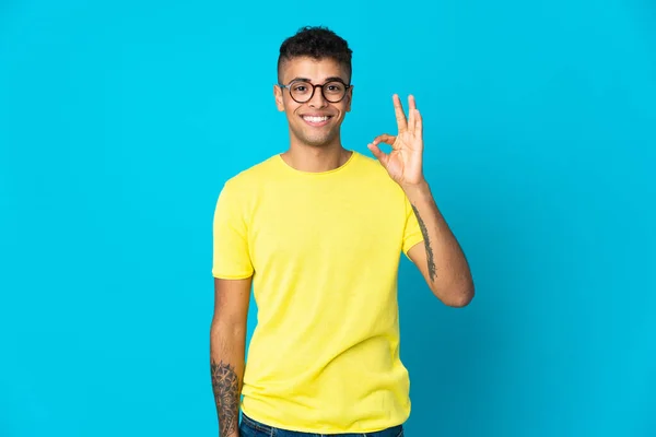 Mladý Brazilský Muž Izolované Modrém Pozadí Ukazující Znamení Prsty — Stock fotografie