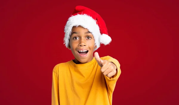 Niño Afroamericano Con Sombrero Navidad Sorprendido Apuntando Adelante Sobre Fondo — Foto de Stock