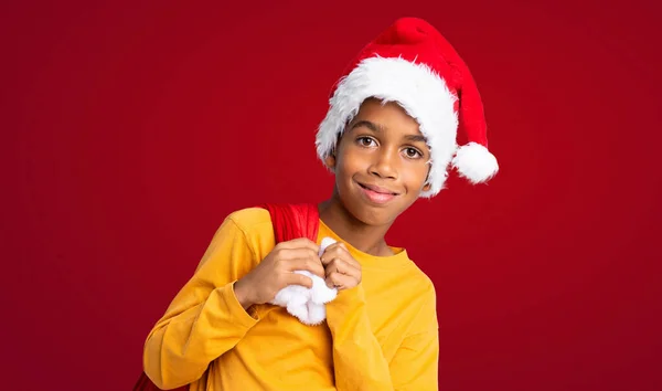 Афроамериканец Рождественской Шляпе Берет Сумку Подарками Красном Фоне — стоковое фото