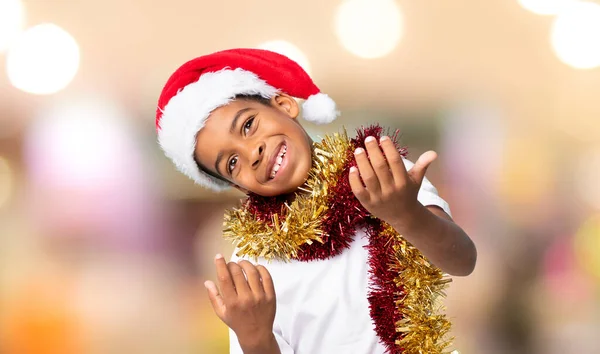 戴着圣诞礼帽的非裔美国男孩邀请人来 很高兴你的背景模糊了 — 图库照片