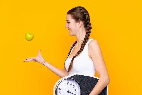 Jeune Femme Sur Fond Jaune Isolé Avec Peseuse Pomme — Photo