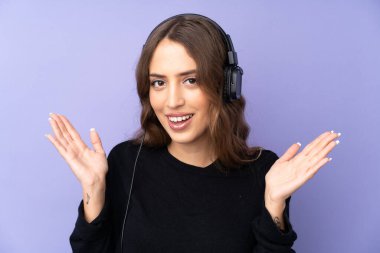 Mor arka plan aşırı izole genç kadın şaşırdı ve müzik dinliyor