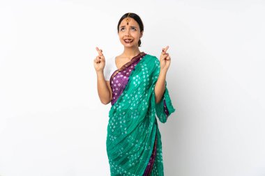 Beyaz arka planda izole edilmiş genç Hintli kadın parmaklarını çapraz yapıp en iyisini diliyor.