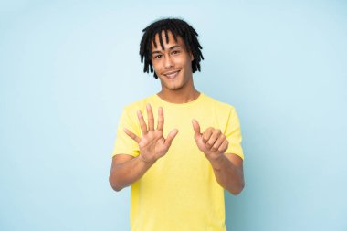 Genç Afrikalı Amerikalı adam mavi arka planda izole edilmiş. Parmakları olan altı kişi saydım.