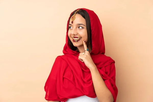 Jovem Indiana Mulher Isolado Bege Fundo Pensando Uma Ideia Enquanto — Fotografia de Stock