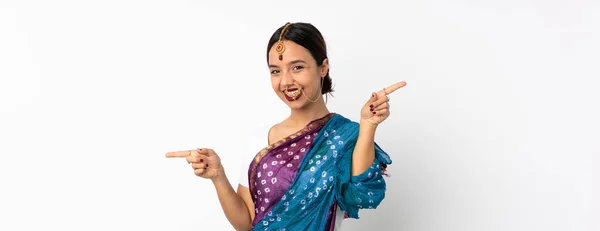 年轻的印度妇女被白色背景隔离 手指指向侧边 很快乐 — 图库照片