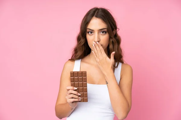 Mladá Žena Nad Izolované Růžové Pozadí Čokoládovou Tabletu Překvapený — Stock fotografie