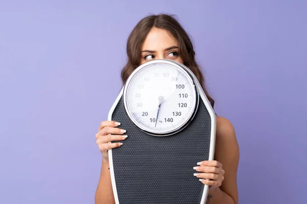 Mujer Deportiva Joven Sobre Fondo Púrpura Aislado Con Máquina Pesaje — Foto de Stock