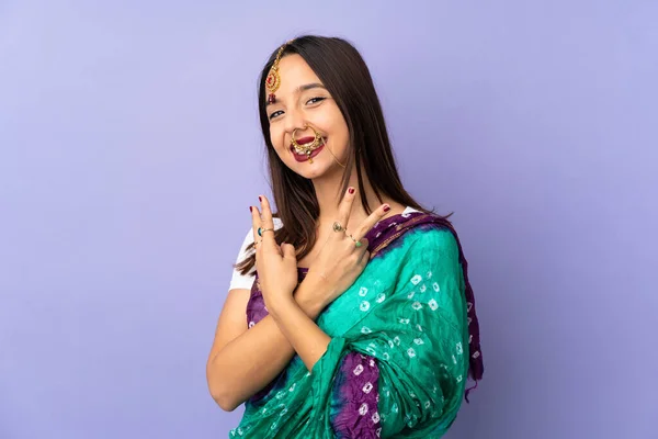 紫の背景に孤立した若いインド人女性笑顔と勝利の兆候を示す — ストック写真