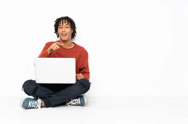 Fiatal Afro Amerikai Férfi Padlón Dolgozik Laptopjával Meglepve Rámutatva Elöl — Stock Fotó