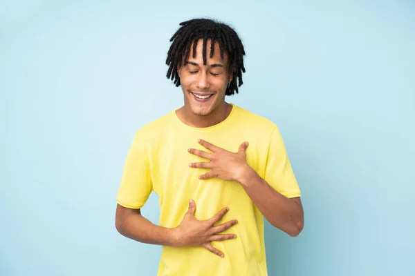 Joven Afroamericano Aislado Sobre Fondo Azul Sonriendo Mucho — Foto de Stock
