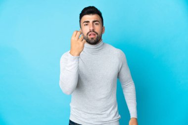 İzole edilmiş mavi arka planda beyaz bir adam İtalyan jesti yapıyor.