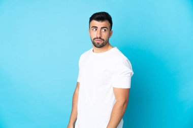 İzole edilmiş mavi arka planda beyaz bir adam. Portre