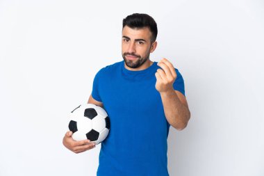 Yakışıklı genç futbolcu izole olmuş duvarın üzerinden para hareketi yapıyor.