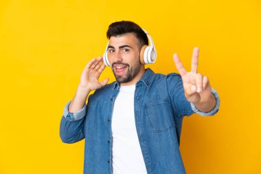 Sarı arka plan üzerinde beyaz bir adam müzik dinliyor ve şarkı söylüyor.