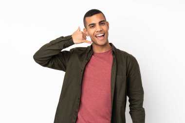 Genç Afro-Amerikalı, izole edilmiş beyaz arka planda telefon jesti yapıyor. Bana geri dönüş işareti ver.