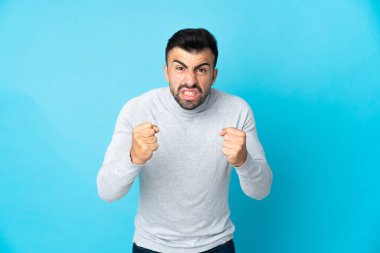 İzole edilmiş mavi arka planı olan beyaz bir adam kötü bir durum yüzünden hayal kırıklığına uğradı.