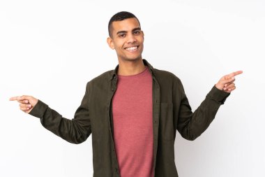 İzole edilmiş beyaz arka planda genç bir Afro-Amerikan erkeği parmak uçlarını işaret ediyor ve mutlu