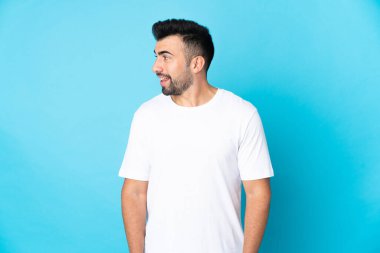 İzole edilmiş mavi arka planda beyaz bir adam.