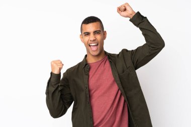 Genç Afrikalı Amerikalı izole edilmiş beyaz arka plan zaferi kutluyor.